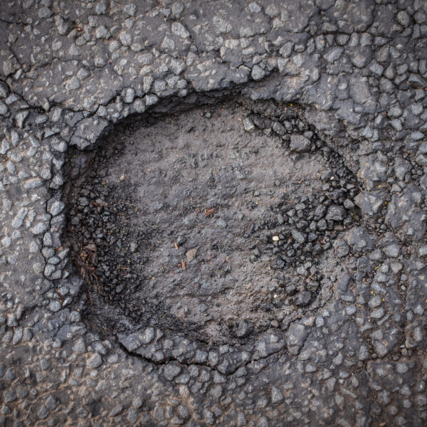 Schlagloch im Asphalt einer Straße