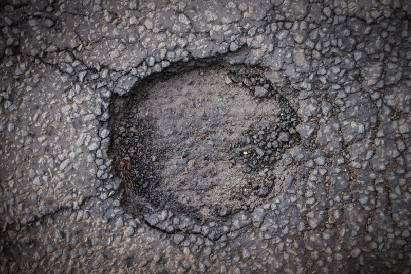 Schlagloch im Asphalt einer Straße