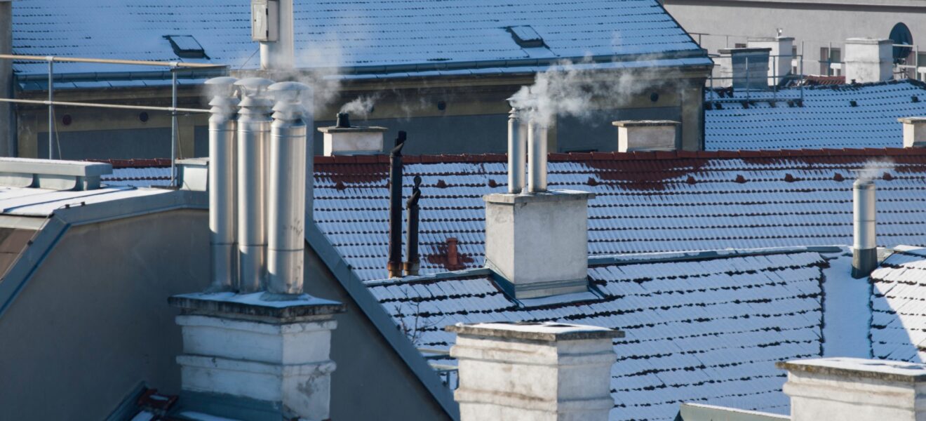 Häuserdächer im Winter mit rauchendem Schornstein