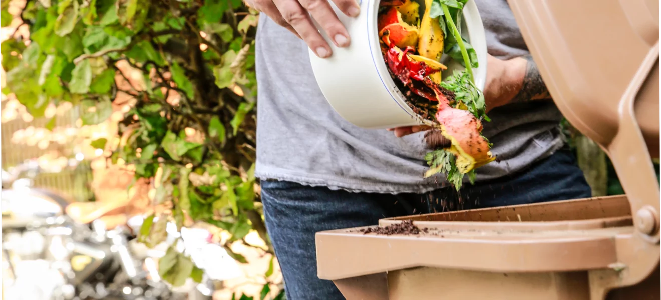 Mann gibt Bioabfall in die Biotonne