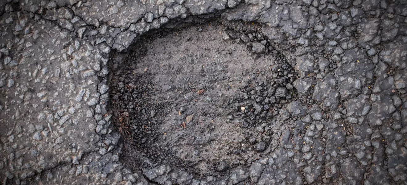 Schlagloch im Asphalt einer Straße